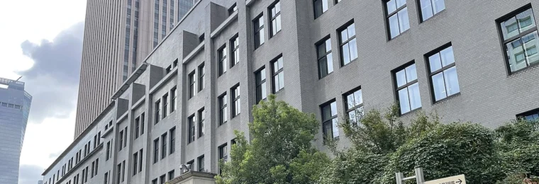 Japan's Ministry of Finance building in Tokyo, with the Japanese flag visible on the tower behind it.