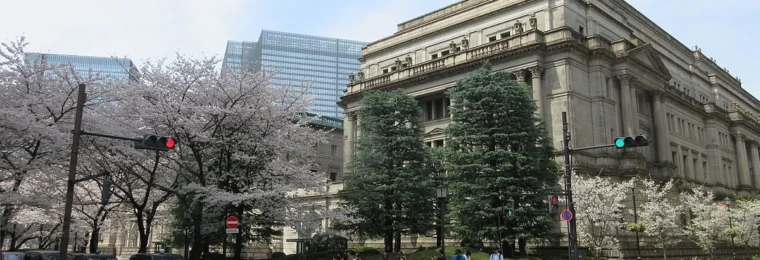 Bank of Japan headquarters in Tokyo with cherry blossoms in the foreground.