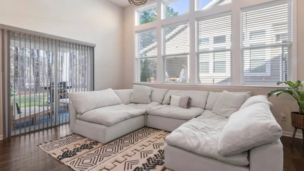 Large light-colored sectional sofa in a bright residential living room.