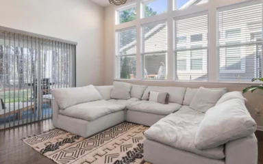 Large light-colored sectional sofa in a bright residential living room.