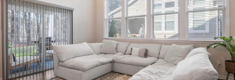 Large light-colored sectional sofa in a bright residential living room.
