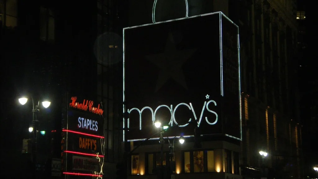 Illuminated Macy’s sign on a building facade at night in New York City.