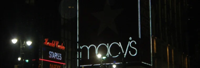 Illuminated Macy’s sign on a building facade at night in New York City.