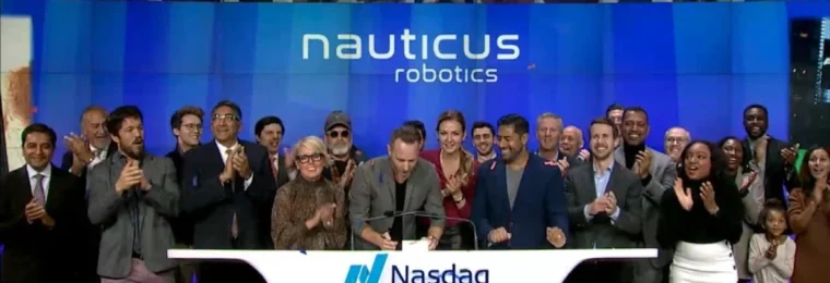 Nauticus Robotics team at a Nasdaq MarketSite event with company branding displayed behind them.