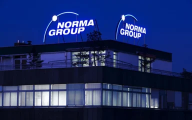 NORMA Group headquarters building in Maintal, Germany, with illuminated NORMA Group signage.