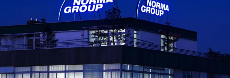 NORMA Group headquarters building in Maintal, Germany, with illuminated NORMA Group signage.