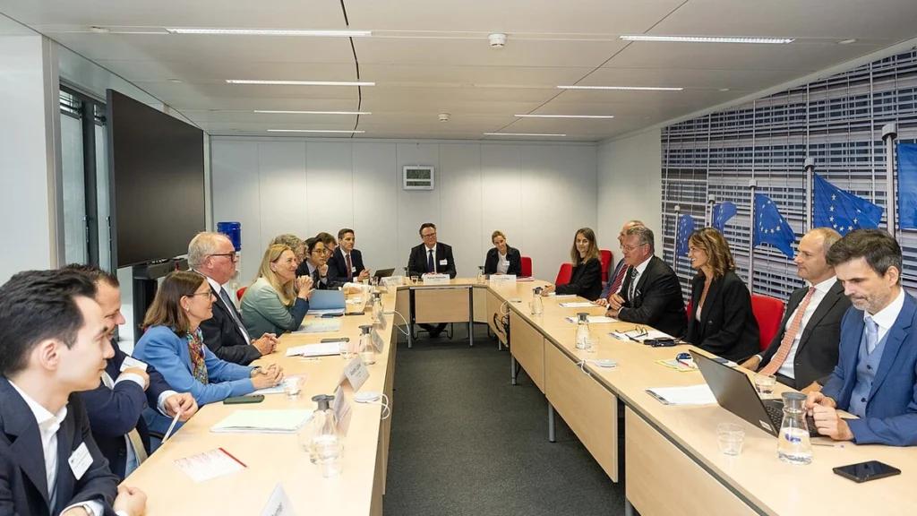 Swiss State Secretary Helene Budliger Artieda seated at a meeting table with European Commission officials in Brussels.
