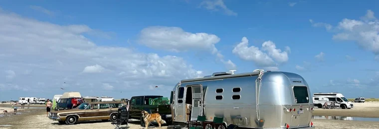 Silver Airstream travel trailer parked on Lakolk Beach on Rømø island, Denmark.