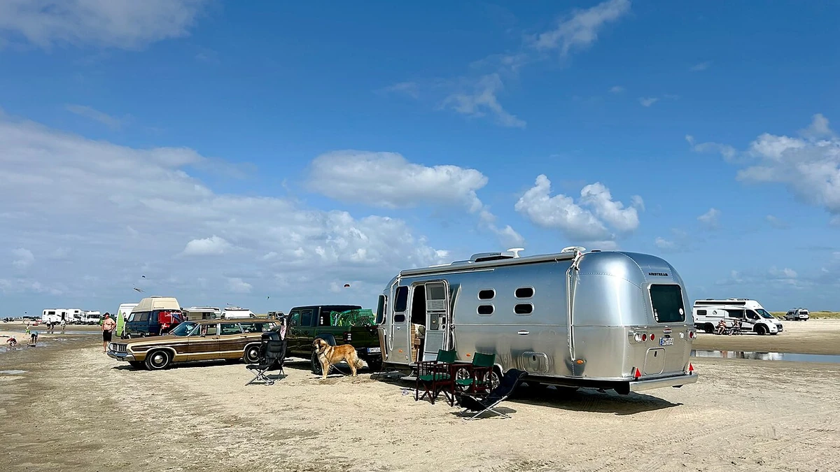 Silver Airstream travel trailer parked on Lakolk Beach on Rømø island, Denmark.