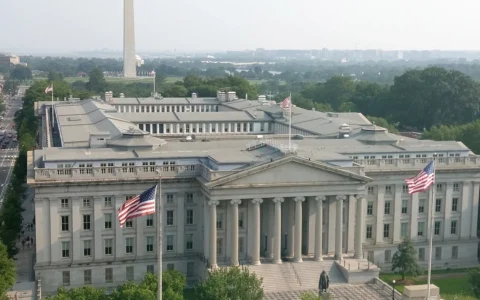 U.S. Treasury Building in Washington, D.C., with the Washington Monument in the background.