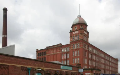Red-brick Manor Mill in Chadderton, Greater Manchester, with its tower and chimney.