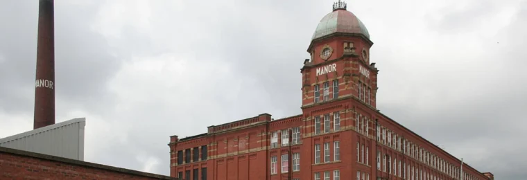 Red-brick Manor Mill in Chadderton, Greater Manchester, with its tower and chimney.