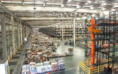 Goods stored on racks and pallets inside a large warehouse distribution center.