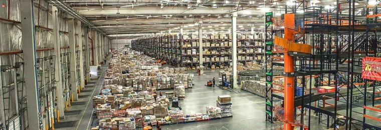 Goods stored on racks and pallets inside a large warehouse distribution center.