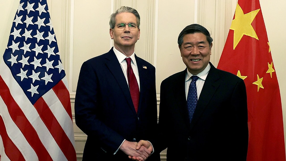U.S. Treasury Secretary Scott Bessent and Chinese Vice Premier He Lifeng shake hands between U.S. and Chinese flags during trade talks in Geneva in May 2025.