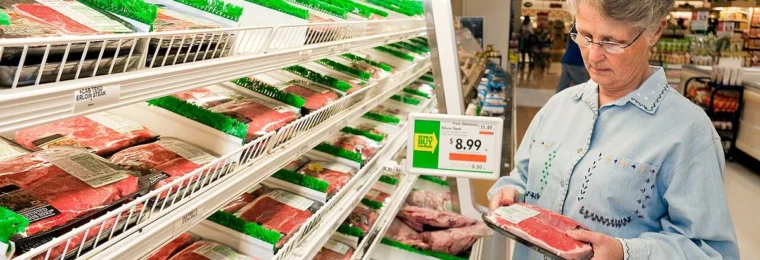 A shopper examines a package of meat in a U.S. grocery store.