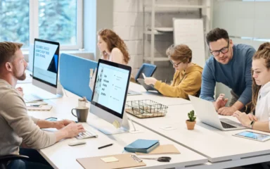 Employees working at computers in a shared office.