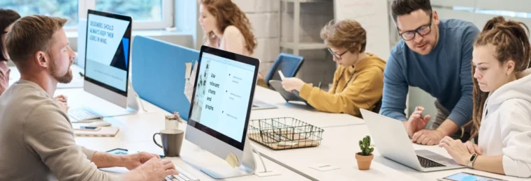 Employees working at computers in a shared office.