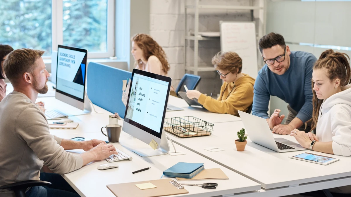 Employees working at computers in a shared office.