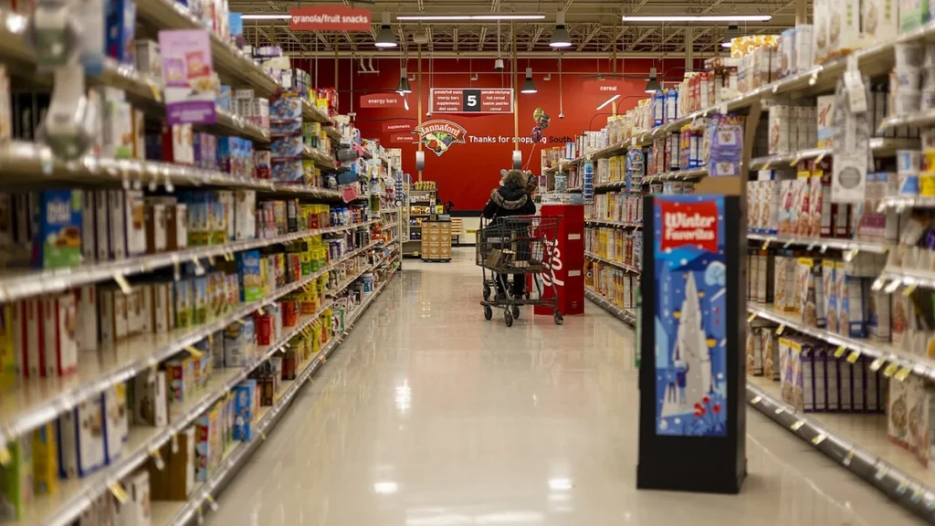 A shopper in a supermarket aisle lined with packaged foods in Vermont.