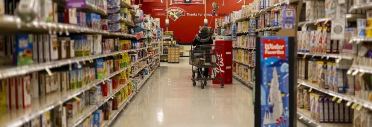 A shopper in a supermarket aisle lined with packaged foods in Vermont.