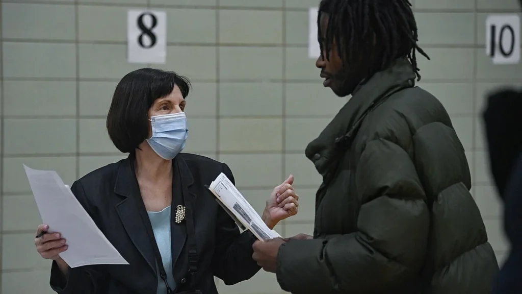 A staff member speaks with a job seeker at a job fair in East Harlem, New York.