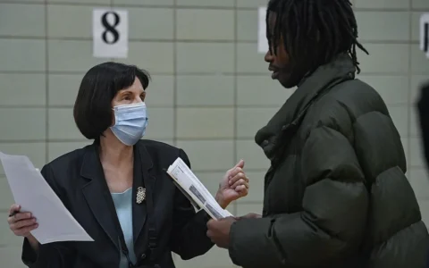 A staff member speaks with a job seeker at a job fair in East Harlem, New York.