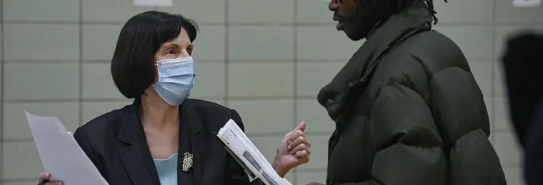 A staff member speaks with a job seeker at a job fair in East Harlem, New York.