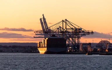 Container ship and cargo cranes at Port Jersey in Upper New York Bay at sunset.