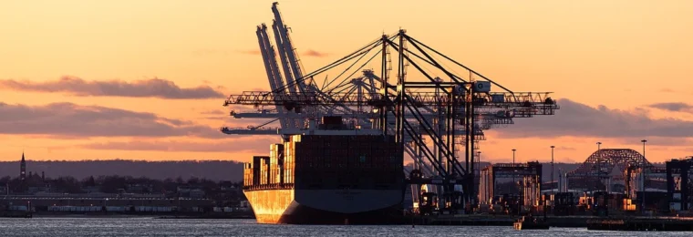 Container ship and cargo cranes at Port Jersey in Upper New York Bay at sunset.