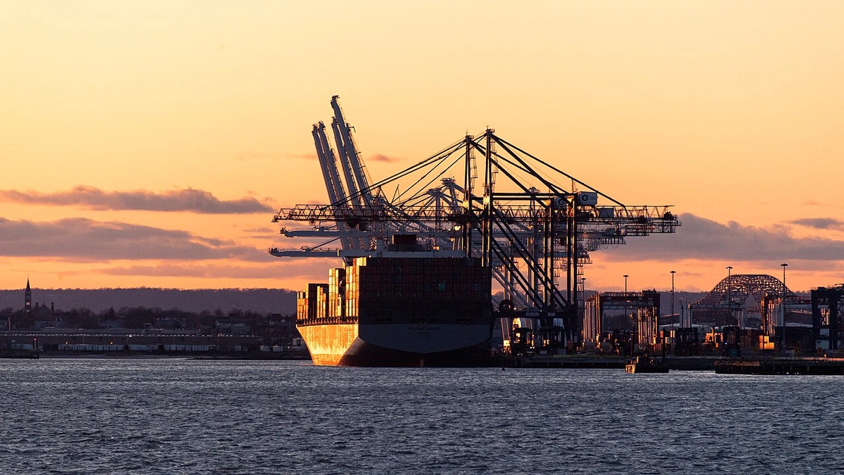 Container ship and cargo cranes at Port Jersey in Upper New York Bay at sunset.