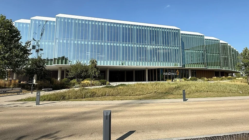 AstraZeneca headquarters in Cambridge, England, with the AstraZeneca sign visible on the building.