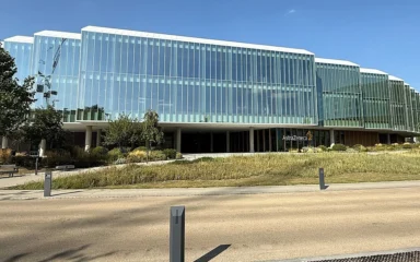 AstraZeneca headquarters in Cambridge, England, with the AstraZeneca sign visible on the building.