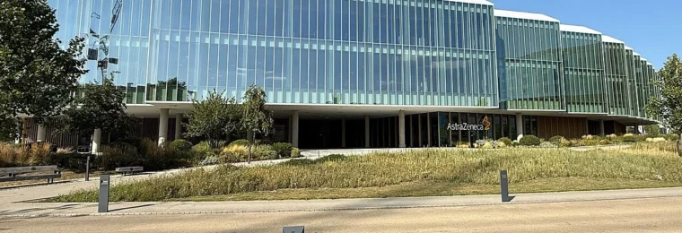 AstraZeneca headquarters in Cambridge, England, with the AstraZeneca sign visible on the building.