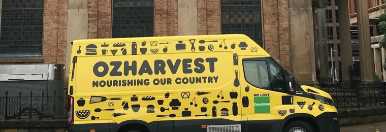 A yellow OzHarvest food delivery van parked outside St James' Church in Sydney, Australia.