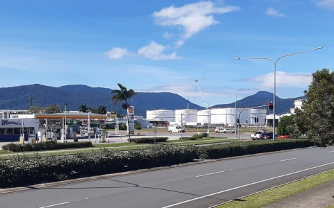 Fuel and gas storage tanks near Cairns Seaport, Queensland, with a roadside petrol station in the foreground.