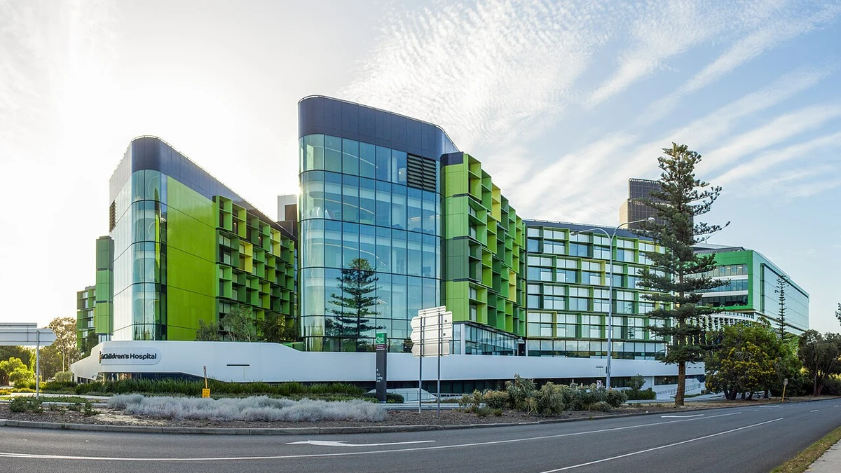 Exterior of Perth Children’s Hospital, showing green and glass-fronted buildings beside a road in 2018.
