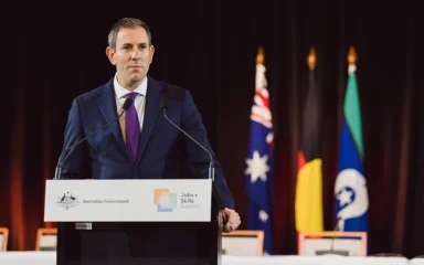 Australian Treasurer Jim Chalmers speaking at a lectern at Parliament House in Canberra.