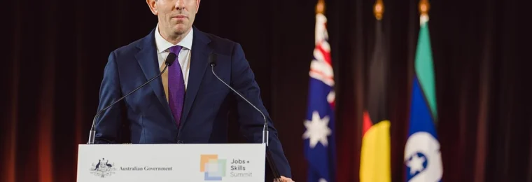 Australian Treasurer Jim Chalmers speaking at a lectern at Parliament House in Canberra.