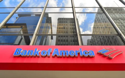 Bank of America signage at a Chicago branch beneath reflective glass windows.