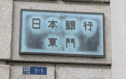 Japanese-language Bank of Japan East Gate sign mounted on the stone wall of its Tokyo headquarters.