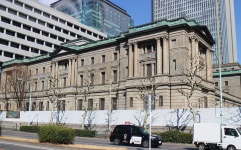 Exterior of the Bank of Japan headquarters in Tokyo, showing its stone facade and columns.
