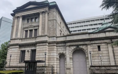 Stone facade, tall columns and arched entrance of the Bank of Japan head office in Tokyo.