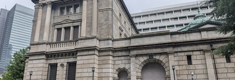 Stone facade, tall columns and arched entrance of the Bank of Japan head office in Tokyo.