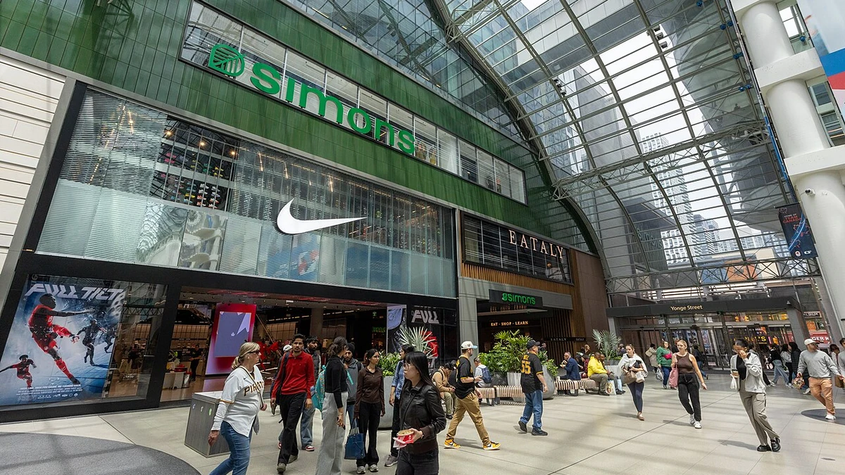 Shoppers walk past the Simons, Nike and Eataly storefronts inside Toronto Eaton Centre.