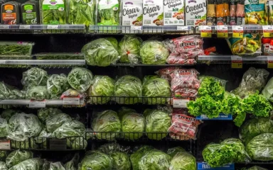 Packaged salads, leafy greens and fresh produce displayed on shelves at an IGA supermarket in Quebec City.