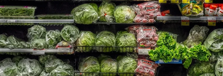 Packaged salads, leafy greens and fresh produce displayed on shelves at an IGA supermarket in Quebec City.