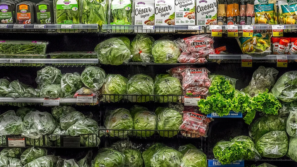 Packaged salads, leafy greens and fresh produce displayed on shelves at an IGA supermarket in Quebec City.