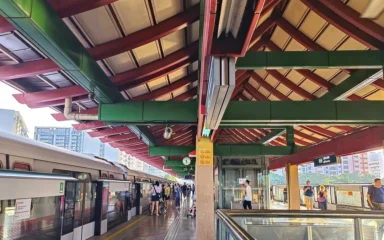 Lakeside MRT station platform in Singapore with an East-West Line train and passengers.