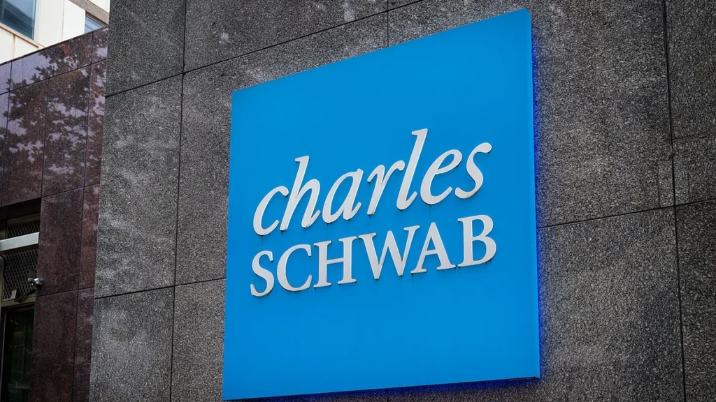 Large blue Charles Schwab sign mounted on the facade of an office building in Bethesda, Maryland.